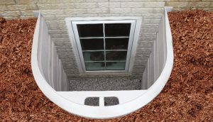 Exterior of basement window with white trim