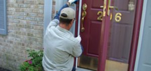 Man repairing exterior door of a house